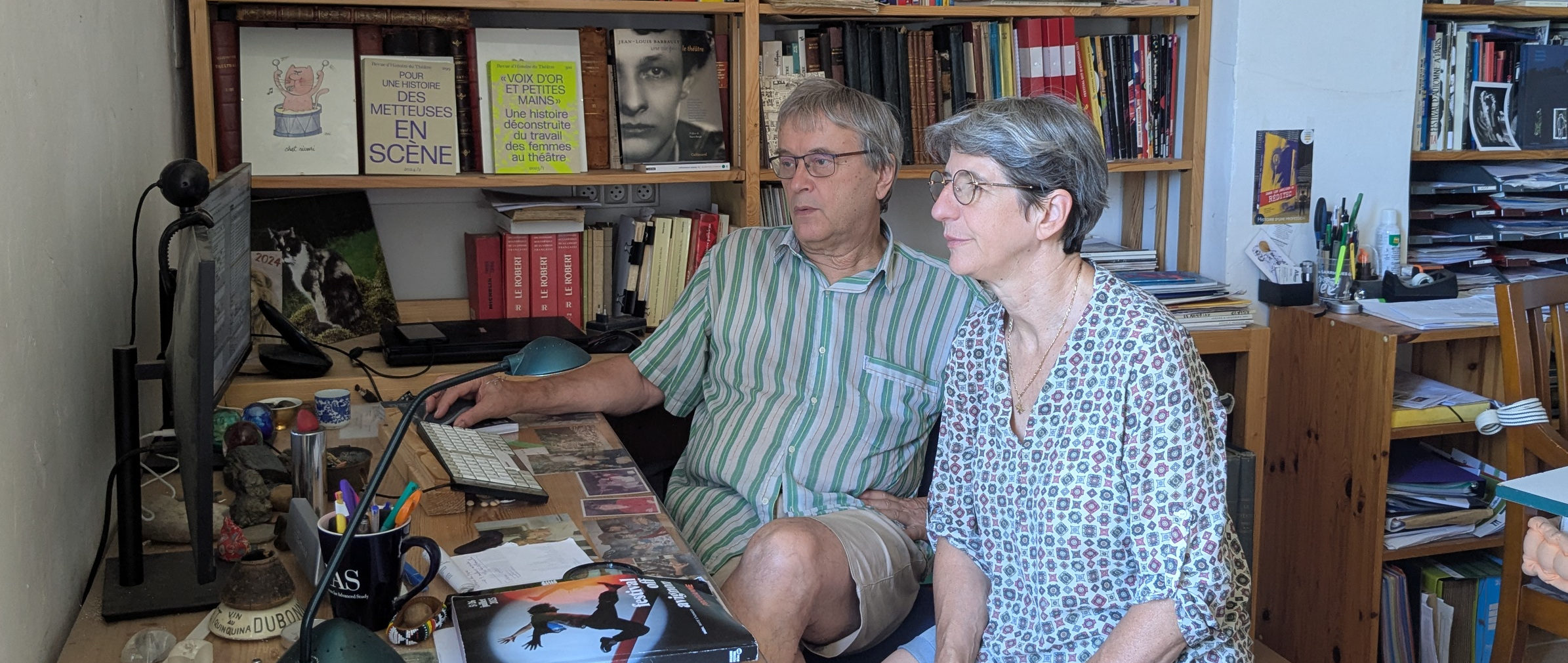 Jacques Brunerie et Martine André, fondateurs du site, dans leur bureau devant un écran d'ordinateur, entourés de livres sur le théâtre.